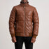 Brown leather jacket worn by a person on a plain background